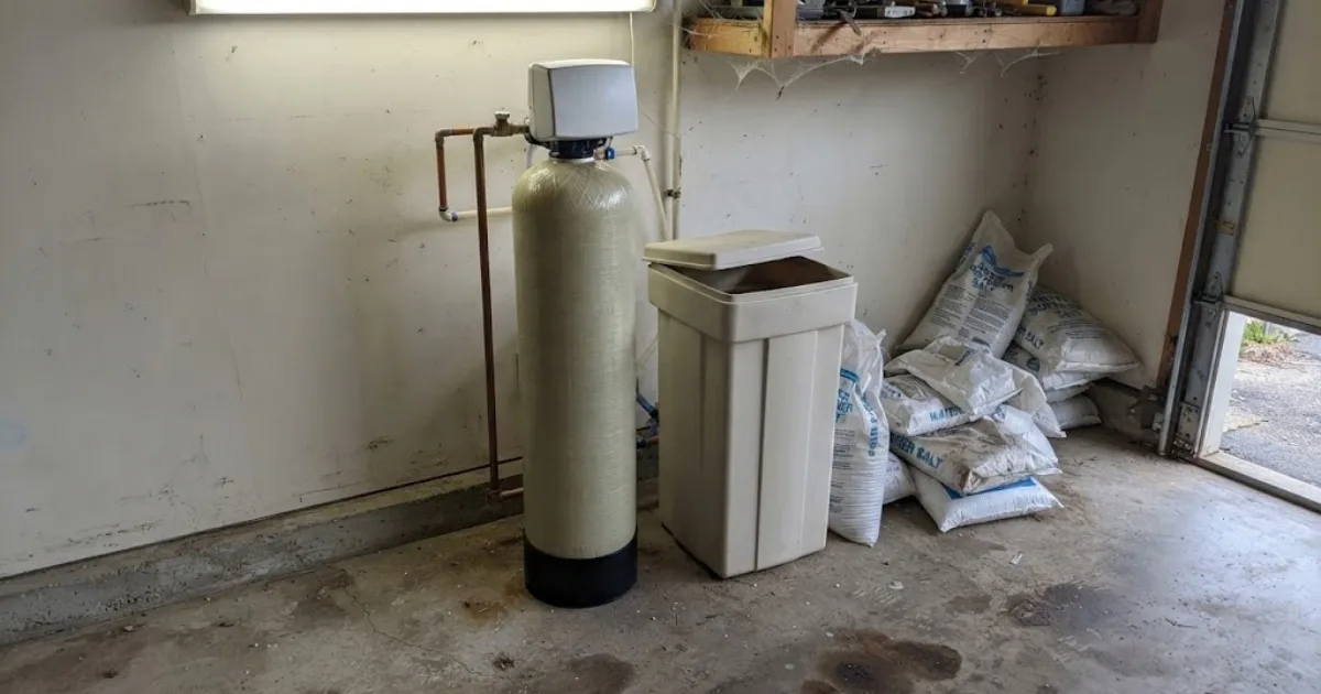 Water softener tank and salt storage bin in a garage corner